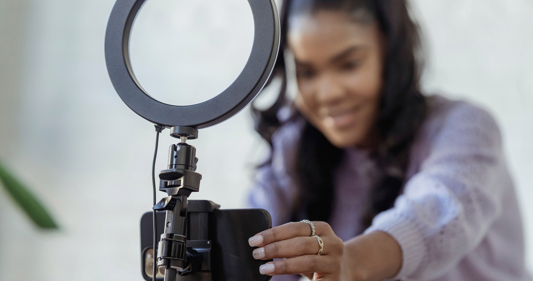 A creator recording smartphone content with a ring light