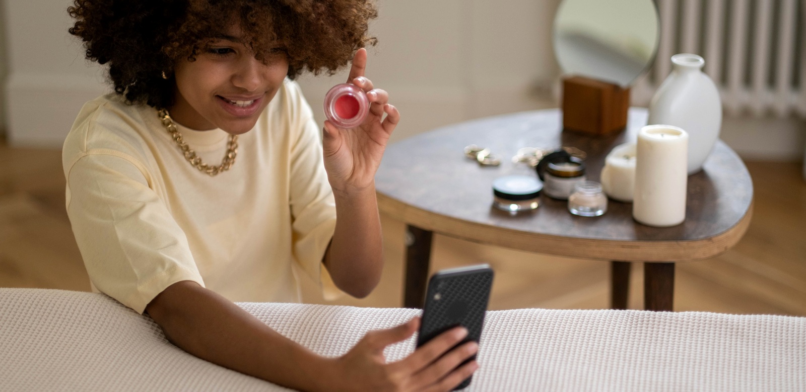 A creator demonstrating a beauty product during a smartphone review